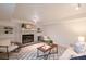 Open living room with a painted brick fireplace and built-in shelving at 5041 S Julian St, Englewood, CO 80110