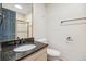 Bathroom with a granite vanity, black fixtures, and a door to the shower at 12008 E Amherst Pl, Aurora, CO 80014