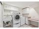 Well-lit laundry area with washer, dryer, sink, and built-in cabinets for ample storage space at 12008 E Amherst Pl, Aurora, CO 80014