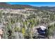 Scenic aerial view of the mountain home nestled among trees, mountains, and open meadows at 12229 Circle Dr, Conifer, CO 80433