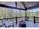 Relaxing covered deck with wooded views, comfortable Adirondack chairs, and a fire pit at 12229 Circle Dr, Conifer, CO 80433