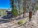 Mountain home with a deck and rustic exterior, nestled among trees and a blue sky at 12229 Circle Dr, Conifer, CO 80433