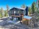 Beautiful home exterior with a spacious deck, gray siding, and a convenient wood storage area at 12229 Circle Dr, Conifer, CO 80433
