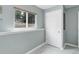 Light-filled hallway featuring a window and white paneled door with gray tile flooring at 12229 Circle Dr, Conifer, CO 80433