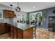 Stylish kitchen island with granite counters, wood cabinets, pendant lights, and a view to the backyard at 12229 Circle Dr, Conifer, CO 80433
