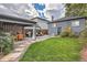 Inviting backyard with a covered patio, seating area, well-manicured lawn and lush landscaping at 1538 Albion St, Denver, CO 80220
