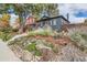 Landscaped front yard with rocks and plants leading to a charming blue house at 1538 Albion St, Denver, CO 80220