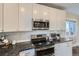 Modern kitchen featuring stainless steel appliances, granite countertops, and white cabinetry at 1538 Albion St, Denver, CO 80220