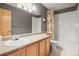 Bathroom featuring wood-finished vanity, countertop, large mirror, and shower with patterned shower curtain at 6190 Sparrow Ave, Firestone, CO 80504