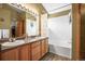 Bathroom featuring a double sink vanity, tub/shower, and decorative lighting at 6190 Sparrow Ave, Firestone, CO 80504