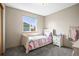Charming bedroom featuring a cozy bed, nightstand, and bright window views at 6190 Sparrow Ave, Firestone, CO 80504