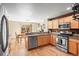 Well-lit kitchen featuring stainless steel appliances, wood floors, and an adjacent dining area at 6190 Sparrow Ave, Firestone, CO 80504