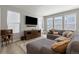 Cozy living room with a large sectional sofa, entertainment center, and light wood flooring at 74 Lullaby Ln, Castle Rock, CO 80109