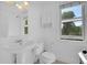 Bright bathroom featuring a classic pedestal sink and ample natural light from the window at 3132 Umatilla St # B, Denver, CO 80211