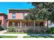 Charming exterior featuring a large covered front porch, beautiful greenery, and a lush front yard at 3132 Umatilla St # B, Denver, CO 80211