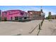An exterior shot of a pink Snarf's Sandwiches restaurant with a parking area and brick buildings nearby at 2325 Walnut St # 4, Denver, CO 80205