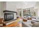 Bright living room features a cozy fireplace, hardwood floors, and large windows with neighborhood views at 2325 Walnut St # 4, Denver, CO 80205