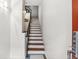 Clean and well-lit stairwell featuring wooden steps, black iron railing, and minimalist lighting at 2325 Walnut St # 4, Denver, CO 80205