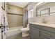 Neutral-toned bathroom with a combined tub and shower, gray vanity, and window at 999 N Emerson St # 9, Denver, CO 80218