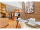 Dining area with hardwood floors, open to kitchen with brick accent wall, and modern lighting fixtures at 999 N Emerson St # 9, Denver, CO 80218