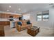 Cozy living room with plush furniture, open to kitchen, and natural light from the window at 16470 Mountain Flax Dr, Monument, CO 80132