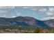 Scenic mountain view overlooking lush green treetops with houses nestled below against a partly cloudy sky at 16470 Mountain Flax Dr, Monument, CO 80132