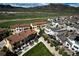 Picturesque aerial view of a neighborhood with modern homes, green spaces, and mountain backdrop at 15576 W Washburn Cir, Lakewood, CO 80228