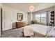 Bright bedroom featuring a plush bed, dresser, and view of the outdoors through a large window at 15576 W Washburn Cir, Lakewood, CO 80228