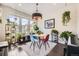 Cozy dining area with colorful seating, large windows with mountain views, modern light fixture and stylish decor at 15576 W Washburn Cir, Lakewood, CO 80228