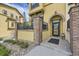 Inviting home entrance featuring a brick-arched doorway, stone accents, and well-manicured landscaping at 15576 W Washburn Cir, Lakewood, CO 80228