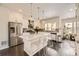 Modern kitchen featuring stainless steel appliances, a large island with seating, and stylish pendant lighting at 15576 W Washburn Cir, Lakewood, CO 80228