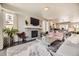 This open-concept living space features a modern fireplace, comfortable seating, and an open flow to the kitchen at 15576 W Washburn Cir, Lakewood, CO 80228