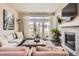 Inviting living room showcasing a fireplace, comfortable seating, and access to an outdoor patio with scenic views at 15576 W Washburn Cir, Lakewood, CO 80228