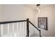 Clean staircase with modern railing and stylish pendant lighting, complemented by artwork at 15576 W Washburn Cir, Lakewood, CO 80228