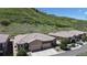 This aerial view showcases a well-maintained home with manicured landscaping and hillside backdrop at 6945 N Fargo Trl, Littleton, CO 80125