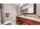 The bathroom features a dark wood cabinet, granite countertop, and a decorative mirror above the sink at 6945 N Fargo Trl, Littleton, CO 80125