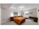 Cozy bedroom with a beige color scheme featuring an orange-covered bed, a desk, and bedside tables with lamps at 6945 N Fargo Trl, Littleton, CO 80125