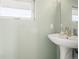 This bathroom features a pedestal sink, large mirror, and a window that provides natural light at 1245 Utica St # 105, Denver, CO 80204