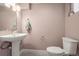 This bathroom features a pedestal sink, a toilet and a towel rack at 1245 Utica St # 105, Denver, CO 80204