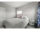 This bedroom features a bed with a white comforter, two bedside tables and an open door at 1245 Utica St # 105, Denver, CO 80204