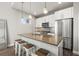 Bright kitchen showcasing a large island with seating, stainless steel appliances, and modern pendant lighting at 1245 Utica St # 105, Denver, CO 80204