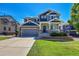 Two-story house with gray siding, brick accents, and a landscaped front yard at 22528 E Layton Cir, Aurora, CO 80015