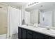 Bathroom featuring double sinks, shower with curtain and large mirror at 7440 S Blackhawk St # 14-103, Englewood, CO 80112