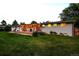 Expansive backyard featuring a covered patio, lush lawn, and mature landscaping at 6243 S Elati St, Littleton, CO 80120