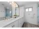 Modern bathroom featuring double sinks, quartz countertop, and a glass-enclosed shower at 6243 S Elati St, Littleton, CO 80120