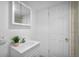 Well-lit bathroom featuring a white vanity, mirrored cabinet, and a door to the shower stall at 6243 S Elati St, Littleton, CO 80120