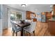 Bright dining area featuring a large dining table, hardwood floors, and access to the backyard at 6243 S Elati St, Littleton, CO 80120