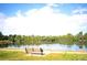 A serene lakeside view with a bench, green grass and trees, ideal for relaxation and reflection at 6243 S Elati St, Littleton, CO 80120