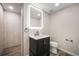 Contemporary bathroom featuring a sleek vanity with lit mirror and wood-look tiled flooring at 8092 Ponderosa Ln, Parker, CO 80138