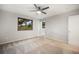 A spacious bedroom featuring a modern ceiling fan and sunlit windows with wooded views at 8092 Ponderosa Ln, Parker, CO 80138